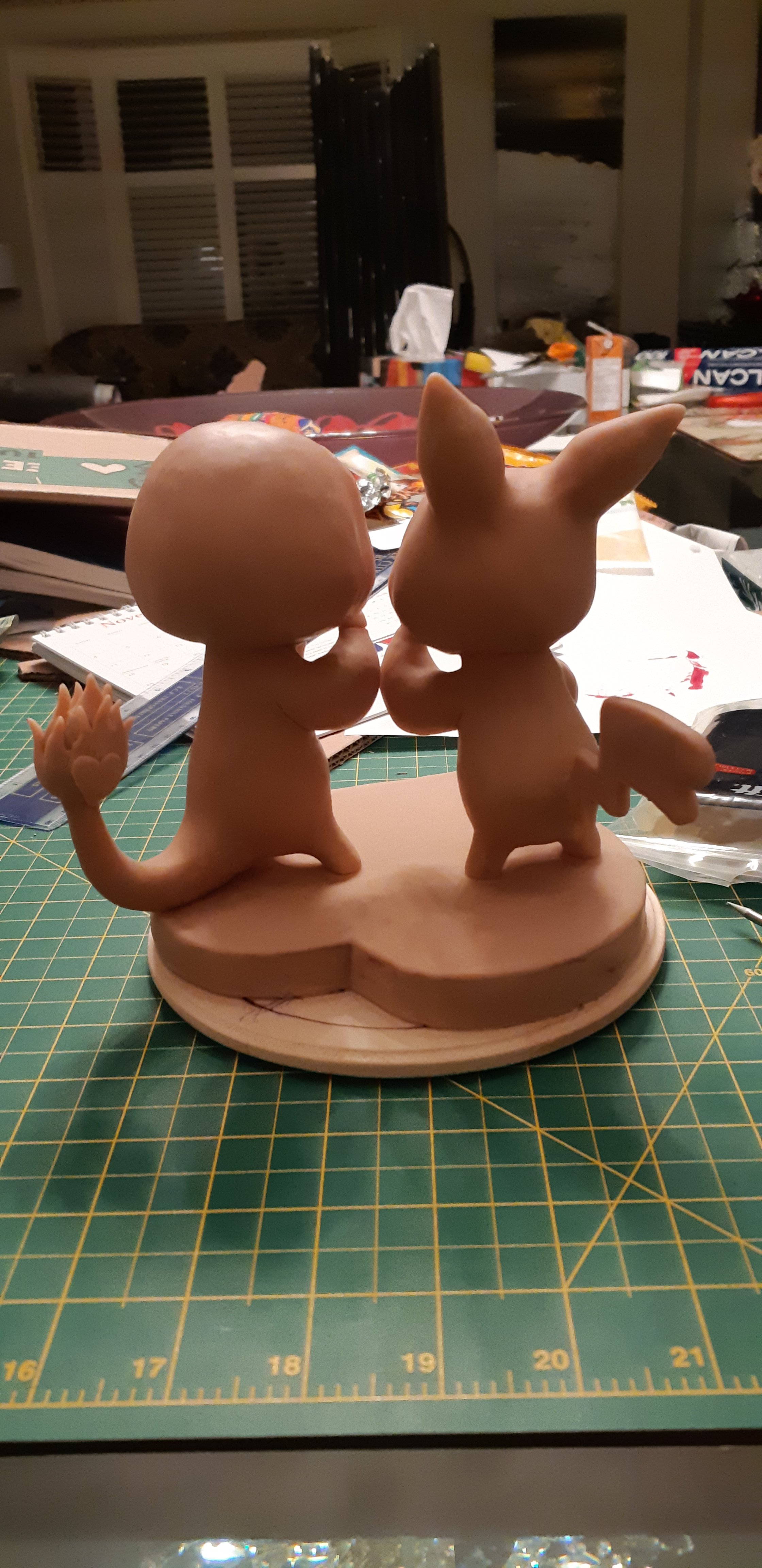 A work-in-progress photo, depicting the unpainted sculpts of the couple. The bodies are covered with sculpey and resemble the couple in the ink drawing. This is the photo of the back of the sculpture.