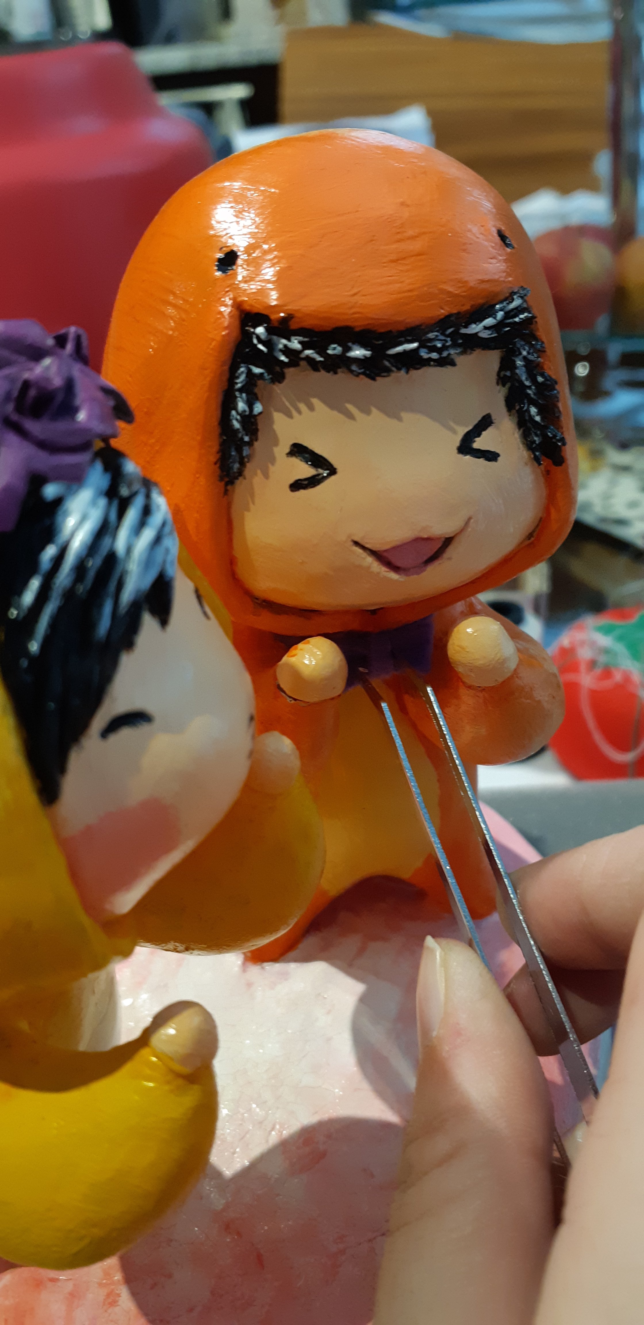A work-in-progress photo, showing the bow tie was glued onto the charmander suit using a pair of tweezers.