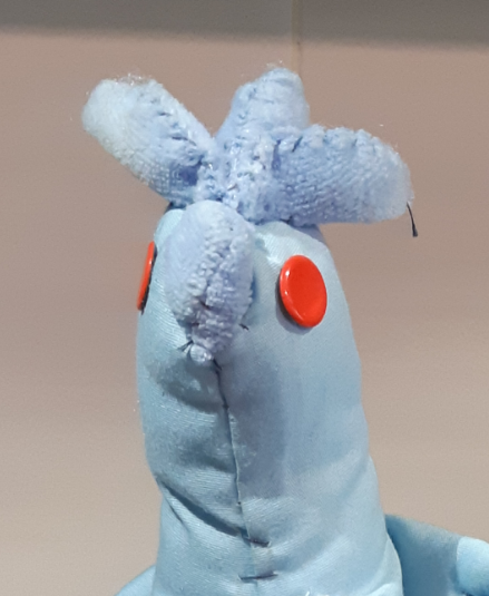 A closeup of the old Articuno plush, showing the metal snap button eyes.