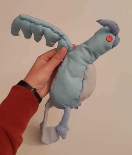 Side view of the old Articuno plush, with one of its wings held up.