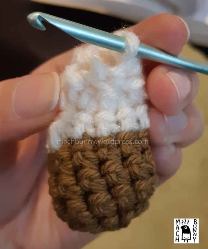 Amigurumi Meowth foot piece, showing result of crocheting top section on top of the existing crochet sides