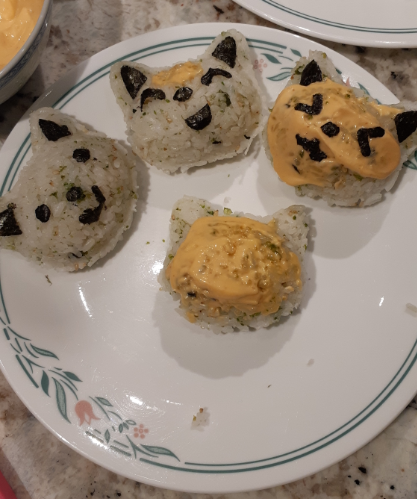Cat shaped rice balls, topped with spicy mayonnaise and seaweed shapes