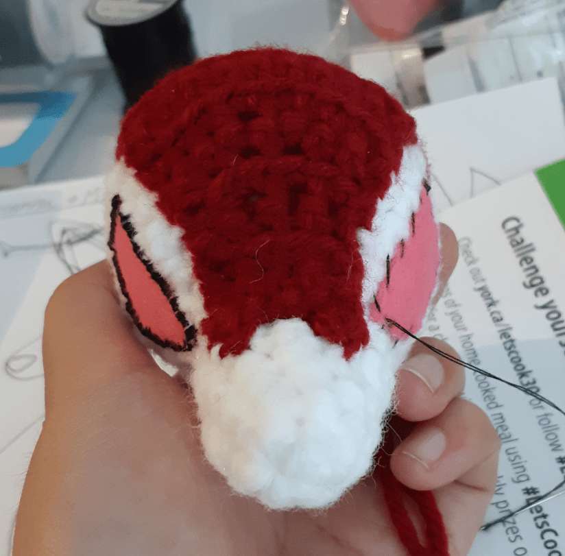 Amigurumi Lycanroc Midnight form, front view of felt eyes partially attached onto base head piece