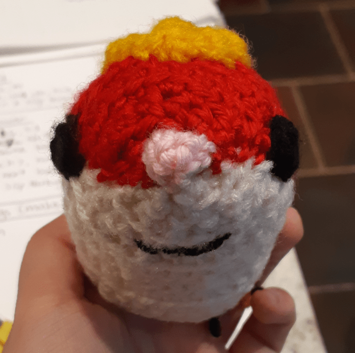 Amigurumi rat, front view of base body with eyes, nose, and mouth attached