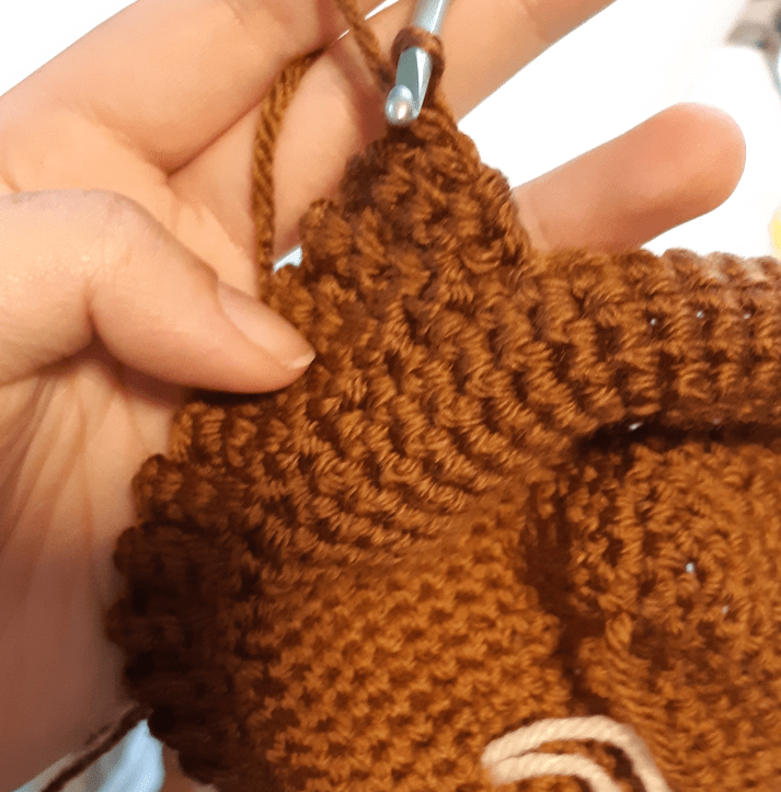 Work in progress photo of the eevee hat base, showing the crocheting ribbing in progress.