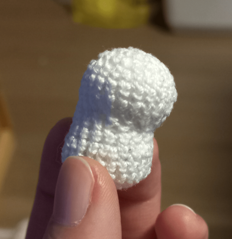 The body of the crocheted Maneki Neko/Lucky cat, which appears to be a white lumpy figure.